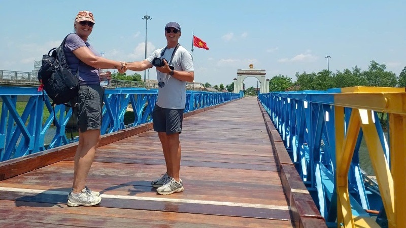 A scenic view of Hue's DMZ region under clear blue skies, featuring historic war sites, lush countryside, and a peaceful rural landscape. The image represents the best seasons and weather conditions for taking a Hue DMZ Tour.